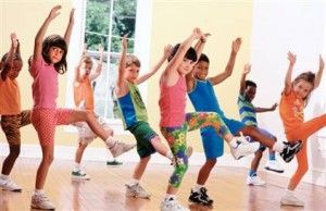 Young preschool children moving around dancing and playing in childcare center